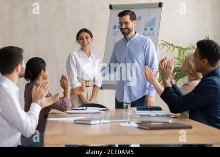 Sorridendo diversi colleghi applaudendo al collega arabo. Foto Stock
