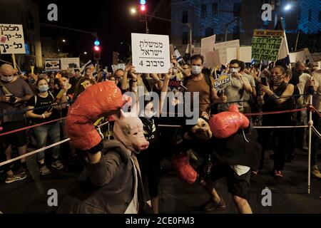 GERUSALEMME, ISRAELE - 29 AGOSTO: Dimostranti israeliani, Uno indossa una maschera di maiale e l'altro come una maschera scimpanzé eseguire una partita di pugilato durante una dimostrazione di massa cui hanno partecipato oltre 25000 persone come parte di continue manifestazioni contro il primo ministro Benjamin Netanyahu per la sua accusa di corruzione e la gestione della pandemia di coronavirus vicino al primo Residenza ufficiale del Ministro il 29 agosto 2020 a Gerusalemme, Israele. Un'ondata di proteste anti-Netanyahu ha spazzato Israele durante l'estate, con la più grande manifestazione settimanale che si svolge ogni sabato sera a Gerusalemme. Foto Stock