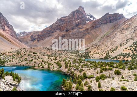 La bella strada di trekking in montagna con cielo azzurro chiaro e. Colline rocciose e la vista del lago Alaudin a Fann Montagne in Tajik Foto Stock