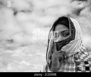 PUSHKAR, INDIA - 01 NOVEMBRE 2019: Giovane donna gitana in abiti tradizionali che coprono parte del suo volto nel deserto di Thar all'alba del 01 novembre 201 Foto Stock