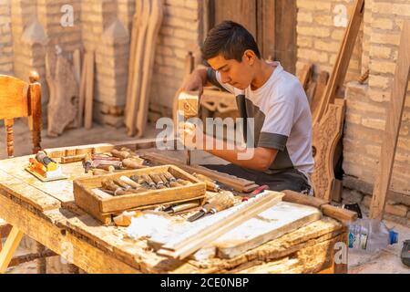 Khiva/Uzbekistan:08.20.2019-i giovani maestri del legno al lavoro Foto Stock