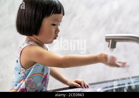 Ragazza asiatica che si lava la mano per l'igiene. Foto Stock