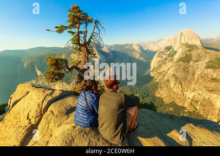 Yosemite, California, Stati Uniti - 9 luglio 2019: Coppia di turisti a Glacier Point nello Yosemite National Park. Glacier Point: Half Dome, Liberty Foto Stock