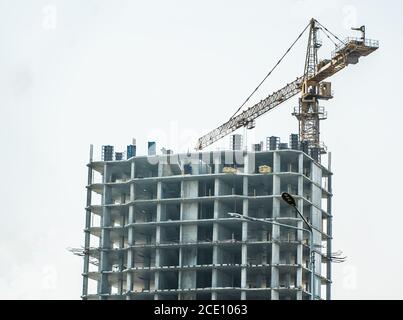 Nuovo edificio in costruzione vista dal basso verso l'alto. Un grattacielo incompiuto, una costruzione congelata. Costruzione incompiuta di una residenza a più piani Foto Stock