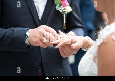 Una coppia nuziale scambia gli anelli di nozze l'uno con l'altro Foto Stock