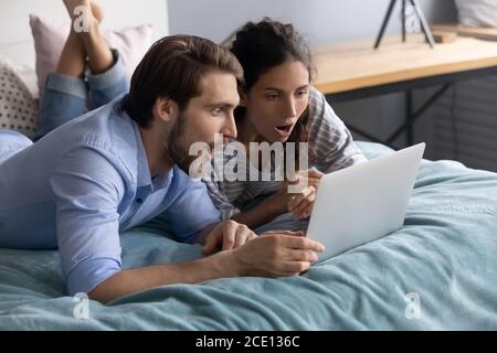 Una giovane coppia di famiglia sorprende che guarda lo schermo del computer. Foto Stock