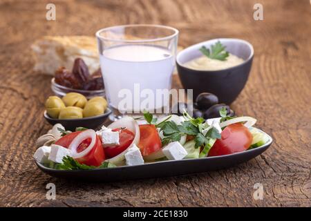 Olive e hummus su legno scuro Foto Stock