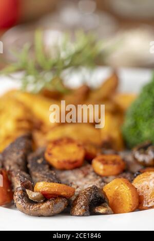 Fette di bistecca con carote e patatine fritte Foto Stock