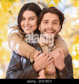 Ritratto dell'uomo felice e della donna che si posano sulla foresta dorata Foto Stock