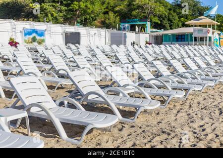 Spiaggia sedie di plastica sulla spiaggia vicino al mare in ora legale Foto Stock