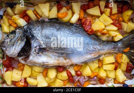 Concetto di pesce orata cucinata in casa. Pesce fresco di orata con verdure, olio e spezie. Pesce sano, dietetico, nutrizione sfondo. Vista dall'alto. Foto Stock
