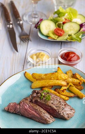 Bistecca su un piatto con patatine fritte Foto Stock