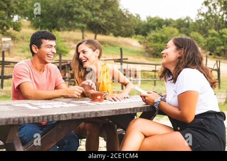 Amici che si divertono e si divertono fuori in un ranch con cavalli e pony. Ranch Concept Photography Foto Stock