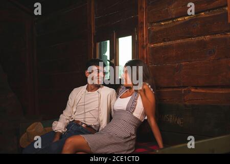 Due amici Flirting e avere una conversazione in un vecchio carro. Ranch Concept Photography Foto Stock