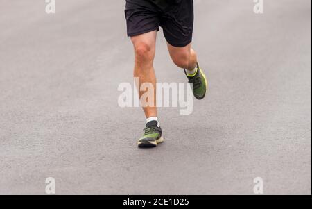 Primo piano dei piedini del corridore. Fitness background, primo piano dei piedi del corridore sulla strada Foto Stock