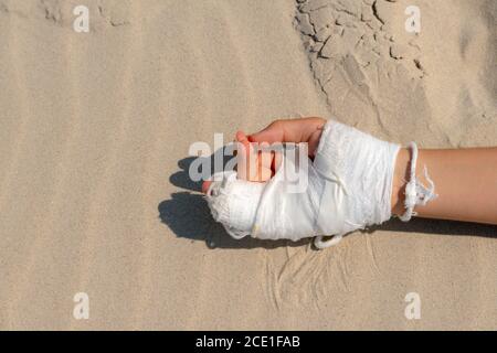 Mano spezzata in calco bianco su sfondo blu con spazio di copia per il testo. Trauma da calco con le dita. Foto Stock