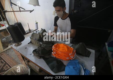 Gaza. 30 agosto 2020. Palestinese Tailor Bilal al-Zomor fa maschere al suo laboratorio nella parte meridionale della striscia di Gaza, città di Rafah, il 30 agosto 2020. Domenica la Palestina ha registrato 536 nuovi casi COVID-19, portando il numero totale di infezioni nei territori palestinesi a 29,063, di cui 166 morti e 19,479 recuperi. Credit: Khaled Omar/Xinhua/Alamy Live News Foto Stock