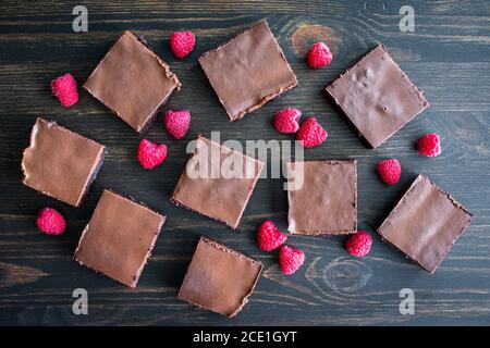 Crostini al tartufo di lampone: Brownie al gusto di lampone ricoperte di ganache al cioccolato e guarnite con lamponi freschi Foto Stock