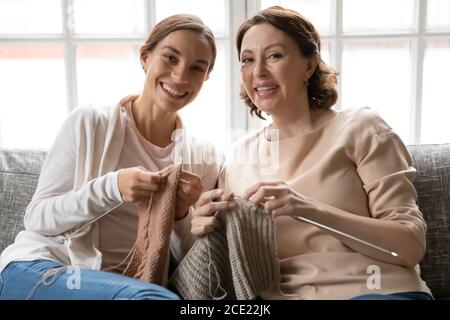 Ritratto di una giovane donna sorridente a maglia con la mamma più anziana. Foto Stock