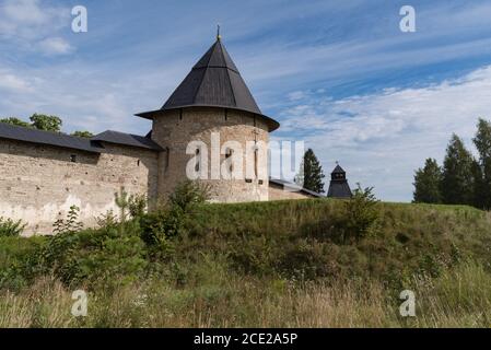 Torre di Izborsk con la parete della fortezza del Monastero di Pskovo-Pechersky Santa Dormizione. Pechory, Russia Foto Stock