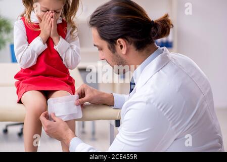 Piccola ragazza che visita giovane medico Foto Stock