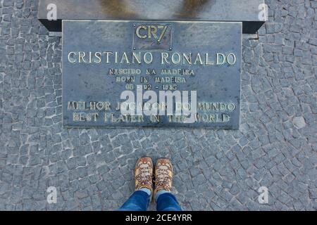 Donna con le sue scarpe vicino a CR7 Cristiano Ronaldo statua placca in CR7 Foto Stock