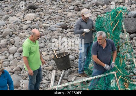 Il volontariato locale di persone la pulizia della spiaggia dopo una tempesta a Ponta do Sol, di Madera Foto Stock