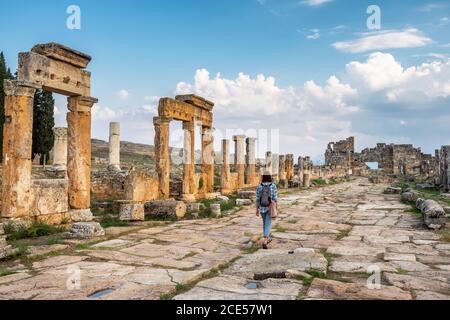 Unidentified donne turistiche passeggiate attraverso le rovine dell'antica città di Hierapolis, Pamukkale, Turchia Foto Stock