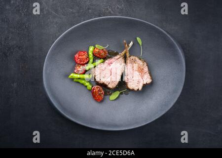 Griglia di collo di agnello con paprika e pomodoro offerto come vista dall'alto su una piastra di design moderna con copia spazio Foto Stock