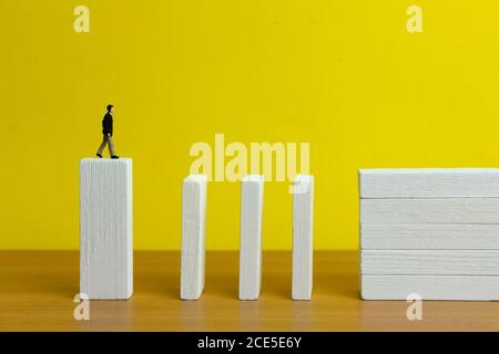 Business strategy Conceptual photo - Miniature of businessman stands at il bordo della scala del ponte di legno Foto Stock