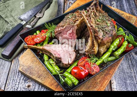 Griglia di collo di agnello con paprika e pomodoro offerto come primo piano su un vassoio di metallo Foto Stock