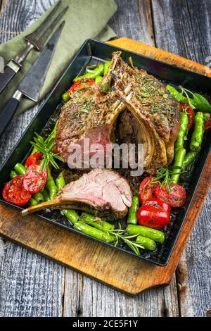 Griglia di collo di agnello con paprika e pomodoro offerto come primo piano su un vassoio di metallo Foto Stock