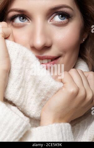 Bionda giovane bella donna vestita di pullover bianco di lana . Foto Stock