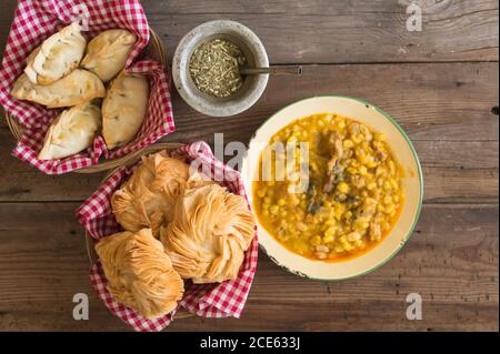 Piatto con empanadas, porzione di loco, torte fritte e mate, menu tradizionale argentino Foto Stock