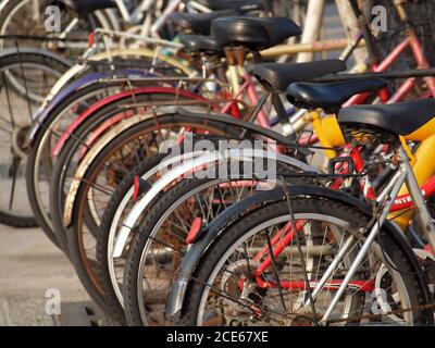 Una fila di vecchie biciclette allineate su una strada Foto Stock