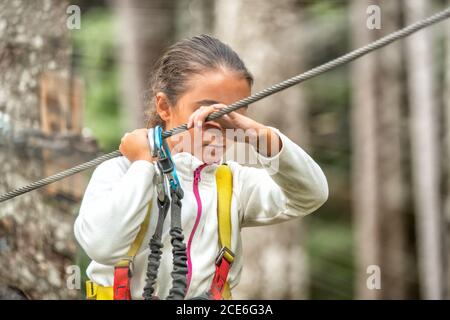 Giovani arrampicatori divertirsi in avventura parco naturale all'aperto - giovani felici persone che fanno sport estremi nel fine settimana, vacanza e concetto di vacanza. Foto Stock