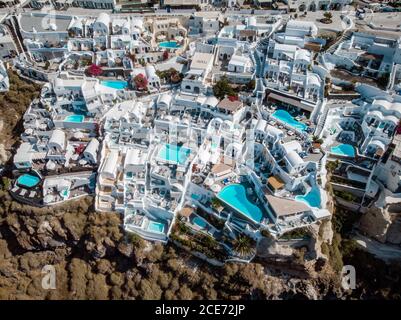 Vista sul drone di Santorini, vista aerea sul villaggio imbiancato di Oia con lussuoso resort per vacanze con piscine infinity a Santorini, Grecia Foto Stock