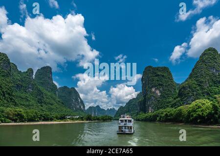 Barca turistica che naviga su un fiume li in Cina Foto Stock