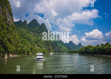 Barca turistica che naviga su un fiume li in Cina Foto Stock