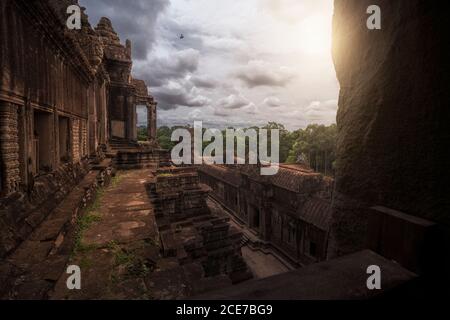 Esterno intemperie dello storico complesso Angkor Wat contro il cielo nuvoloso In Cambogia Foto Stock