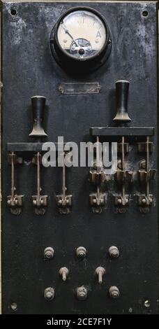 Pannello di controllo in metallo invecchiato con interruttori e indicatori analogici in officina artigianale Foto Stock