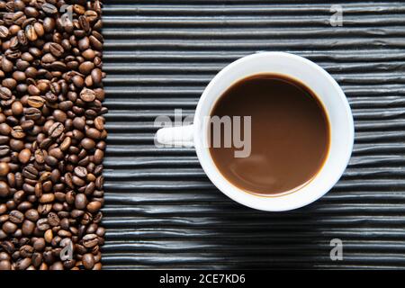 Tazza di caffè e chicchi di caffè sul tavolo Foto Stock