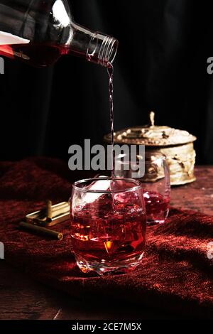 persona anonima che serve il whisky in un bicchiere Foto Stock