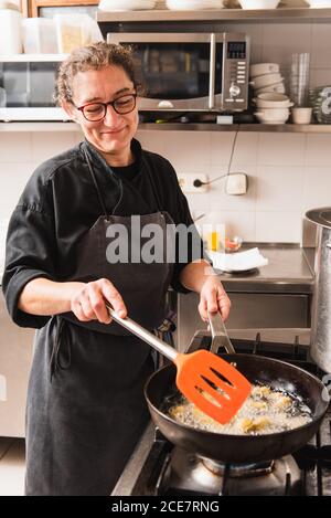 Cuoca i carciofi in una cucina del ristorante Foto Stock