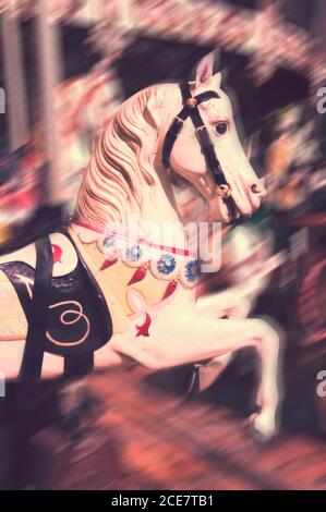 Giostra Vintage cavallo. Stile antico di legno scolpito su un vecchio divertimento Merry Go Round, motion blur. Foto Stock