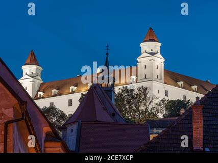 Parte del castello di bratislava con la torre della chiesa nella parte anteriore della sera. Foto Stock