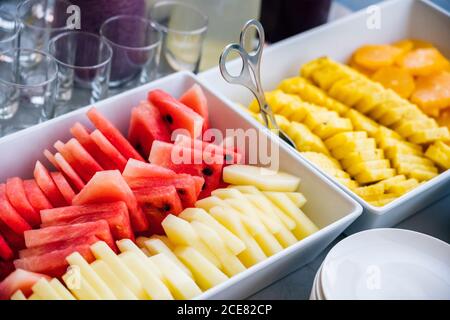 Alto angolo di fette di cocomero fresco e melone messo su tavola con pezzi di arance e ananas Foto Stock
