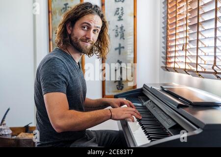 Uomo di talento che suona il pianoforte a casa Foto Stock