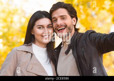 Primo piano di felice coppia che prende selfie in autunno foresta Foto Stock