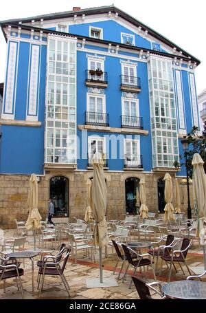 Edificio bianco e blu su una piazza con terrazza Pieno di tavoli e sedie e ombrelloni solcati Burgos Castiglia E Leon Spagna Foto Stock